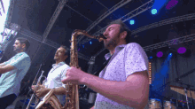 a man playing a saxophone in a band with other men