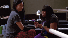two women sitting at a piano holding hands and smiling