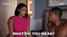 a man and a woman are sitting on a bed and the woman says " what do you mean "