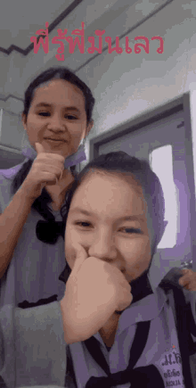 two girls are posing for a picture and one of them is wearing a uniform that says aqua