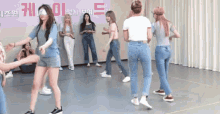 a group of women are dancing on a dance floor in front of a sign that says ' a ' on it .