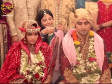 a bride and groom are sitting next to each other with dangal tv in the background