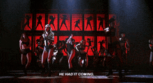 a group of people are dancing on a stage with the words he had it coming below them