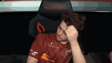 a man in a red shirt is sitting in a chair that says respawn