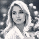 a black and white photo of a woman holding a flower