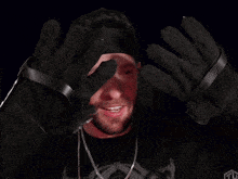 a man with a beard wearing a black hat and gloves