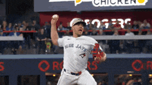 a man in a blue jays jersey throws a baseball
