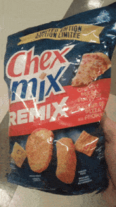 a person is holding a bag of chex mix remix pizza flavored crackers