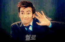 a man in a suit and tie is waving his hand in front of a foreign language