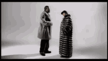 two men are standing next to each other and one is wearing a fur coat
