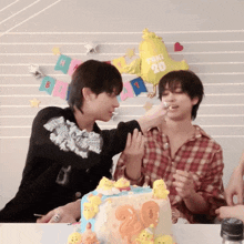 a man is feeding another man a piece of cake with a balloon that says 20 on it