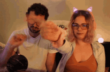 a man and a woman are standing next to each other in front of a pillow that says " i do "