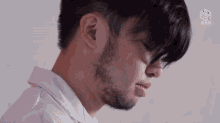 a close up of a man 's face with a cube logo in the corner