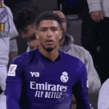 a soccer player wearing a purple jersey with emirates fly better on it .