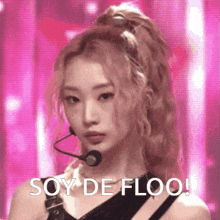 a woman with blonde hair is wearing a microphone and says soy de floo !