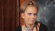 a woman with a ponytail is making a face and saying yes .