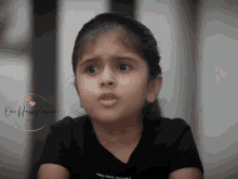 a little girl wearing a black t-shirt with the words " make future better " on the front