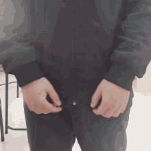 a person wearing a black jacket with a zipper that says ' s ' on it