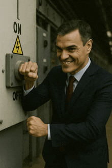 a man in a suit is pressing a button that says on
