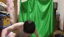 a man is standing in front of a green screen in a room .
