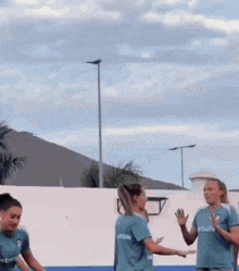 a group of female soccer players wearing blue shirts with the word house on the back