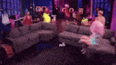 a woman in a pink wig is sitting on a couch in a living room