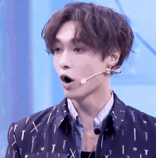 a close up of a young man wearing a microphone and a shirt with screws on it .
