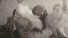 a woman in a white dress is dancing in a room with smoke coming out of her hands .