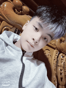 a young boy laying on a wooden couch with chinese writing on the bottom right
