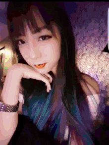 a woman with blue and purple hair is wearing a watch on her wrist