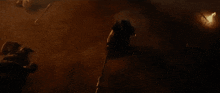 a person is holding a ring in a dark room surrounded by fire