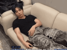 a man is laying on a couch with korean writing on the bottom