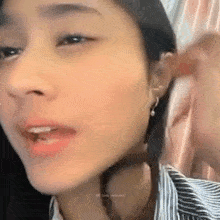 a close up of a woman 's face with a piercing in her lip .