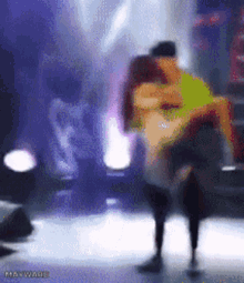 a blurry picture of a man holding a woman in his arms