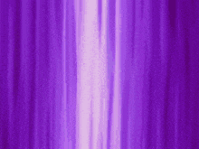 a purple curtain is moving in the wind with a white light coming out of it .