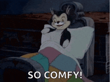 a cartoon cat is laying in a bed with the words `` so comfy '' written below it .