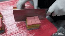 a person is cutting a piece of food on a cutting board that says made in animatica