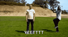 two men are standing in a grassy field and one of them is saying yeetttt