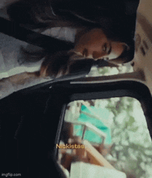 a woman is sitting in the back seat of a car looking out of the window .