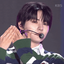 a close up of a person 's face with a kbs logo in the corner