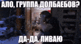 a man is talking on a cell phone in a dark room with russian writing on it