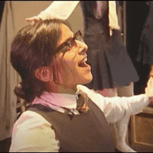 a woman wearing glasses and a bow tie is singing