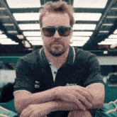 a man wearing sunglasses and a black shirt with the word boss on it