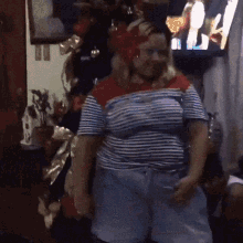 a woman is dancing in front of a christmas tree .