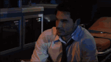 a man in a white shirt and tie looks down