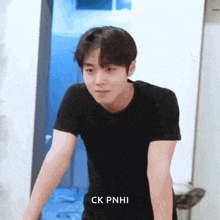 a young man in a black shirt with ck pnhi on the bottom