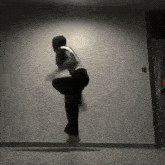 a person is jumping in the air in front of a white wall