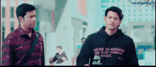 a man wearing a hoodie that says we 're changing the way things get made stands next to another man
