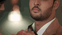 a man with a beard is adjusting his tie with a woman