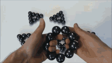 a person is holding a bunch of black balls